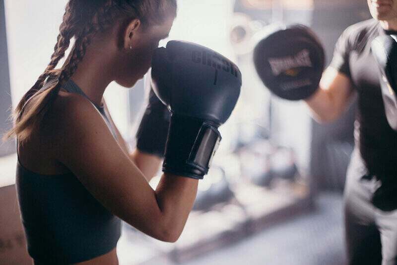 Mulher com luvas de boxe em posição de combate