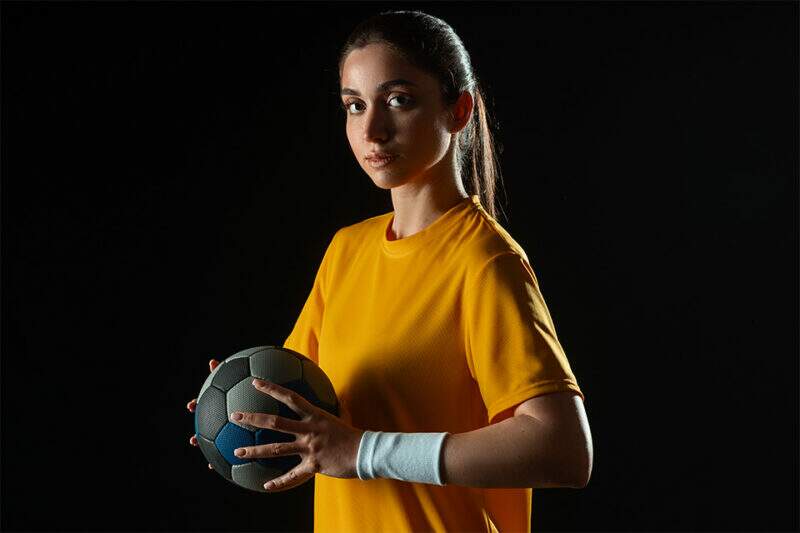 Mulher segurando bola de handebol